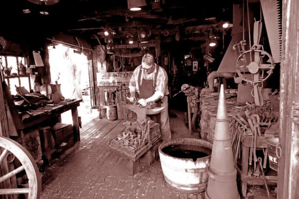 blacksmith working surrounded by tools