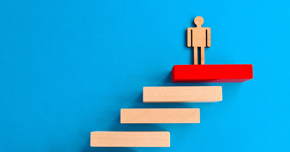 Photo illustration of wooden steps and a figurine on the top step