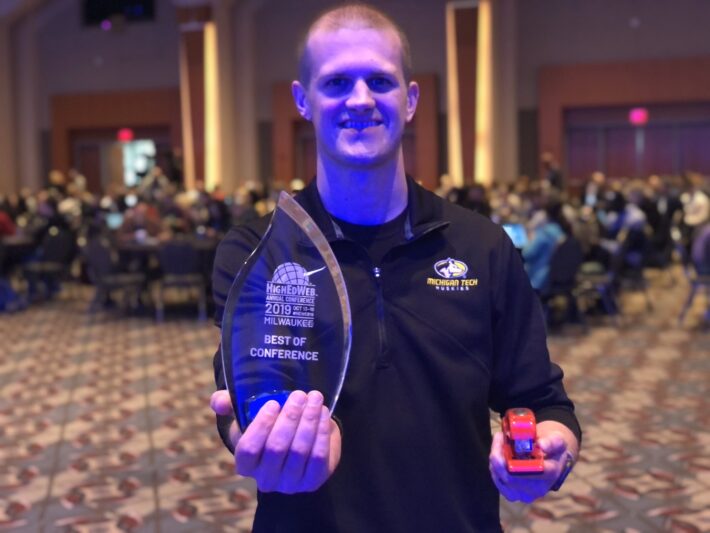 joel vertin with an award and red stapler