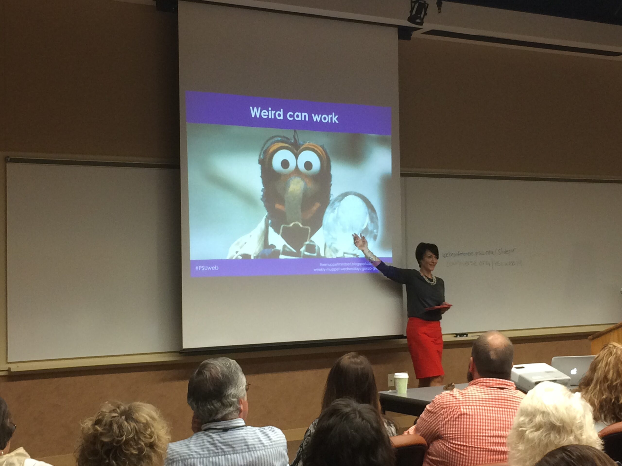 Tonya Oaks Smith at a HighEdWeb presentation about social media and muppets pointing to a slide featuring Gonzo that says "Weird can work"