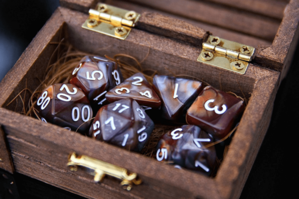 A wooden box with dice inside. The dice have different numbers of sides, from 20 to 4