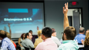 Classroom with one student with raised hand to ask question