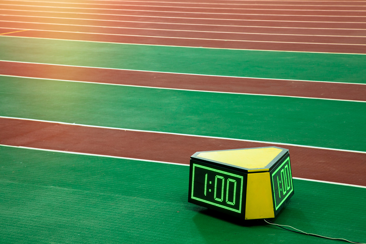Track and field with stripes of green grass, with a timer set to 1 minute in the foreground